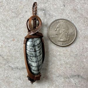 Copper wrapped fossil pendant.